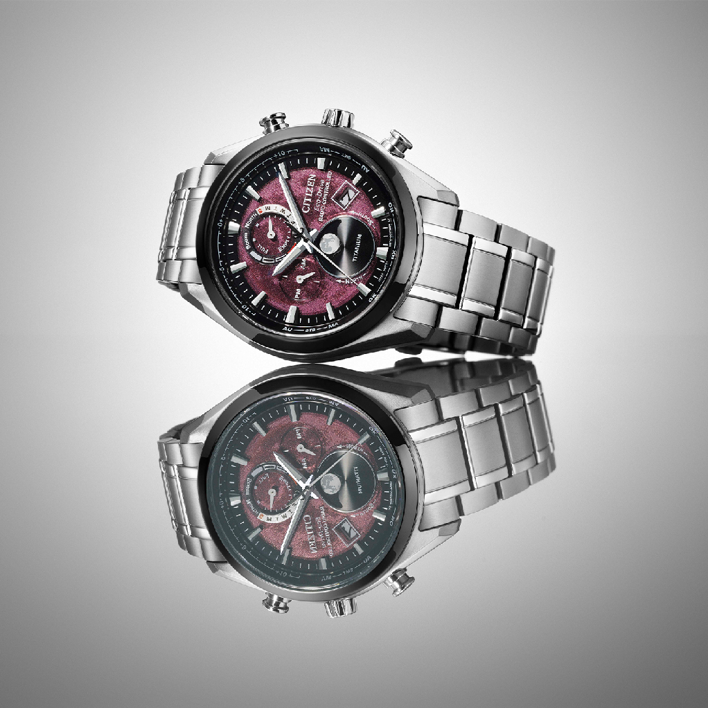 Citizen-Uhr mit rotem Zifferblatt und Titanarmband, spiegelt sich auf einer Oberfläche.