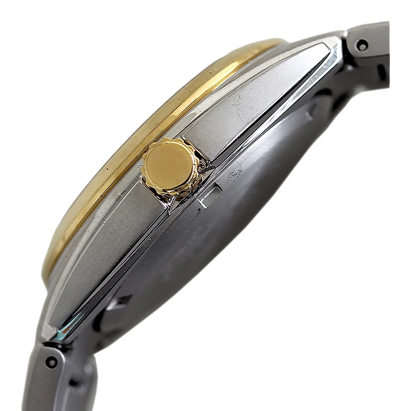 Nahaufnahme einer goldenen und silbernen Uhr mit Krone und Armband