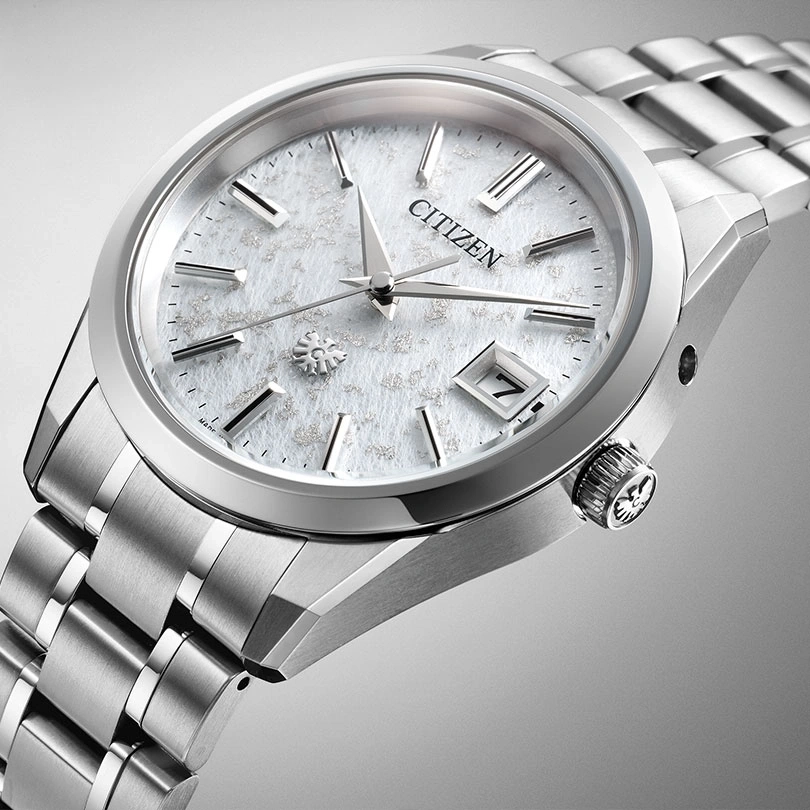 Citizen-Uhr mit weißem Zifferblatt und silbernem Armband, elegantes Design.