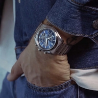 Ein Mann trägt eine blaue Citizen-Uhr und eine Jeansjacke