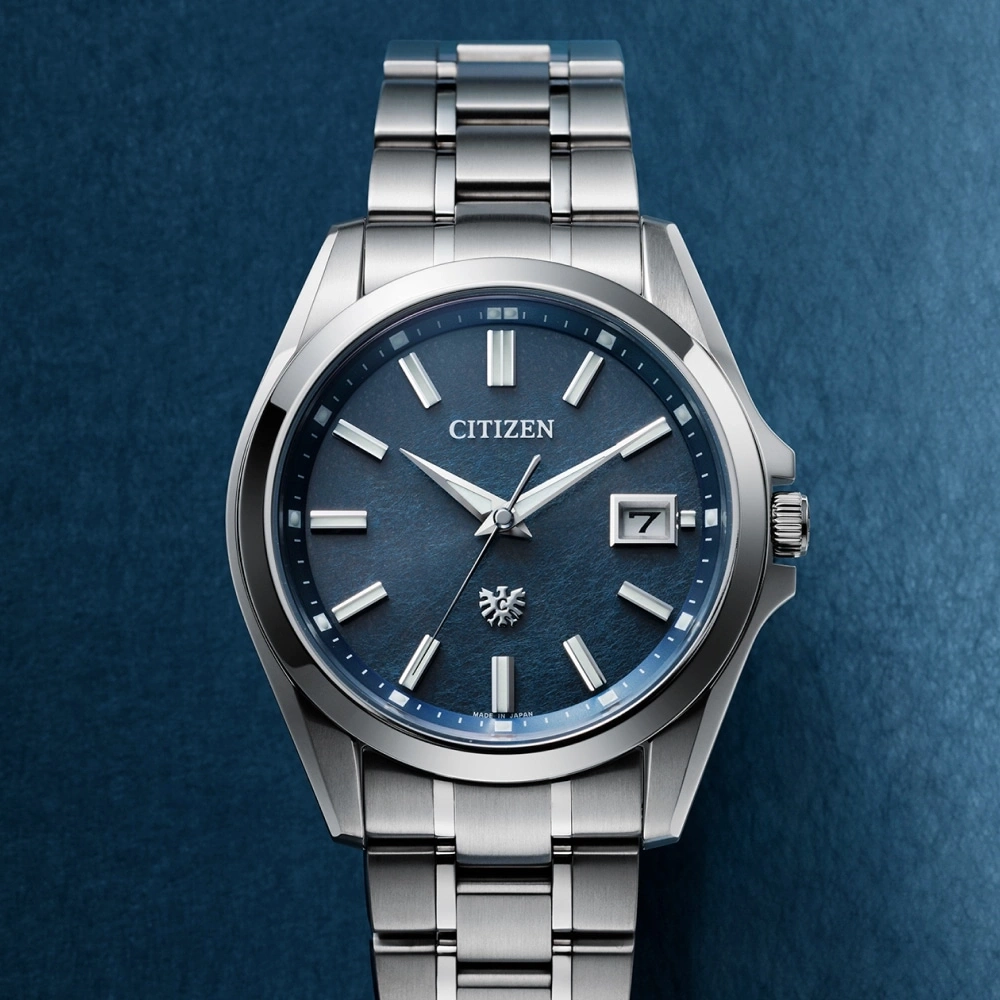 Citizen-Uhr mit blauem Zifferblatt und silbernem Armband auf blauem Hintergrund