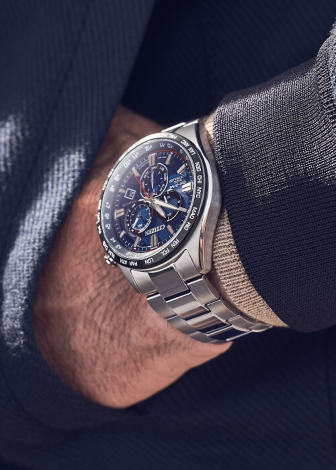 Nahaufnahme einer Citizen-Uhr am Handgelenk, mit blauem Zifferblatt und silbernem Armband.
