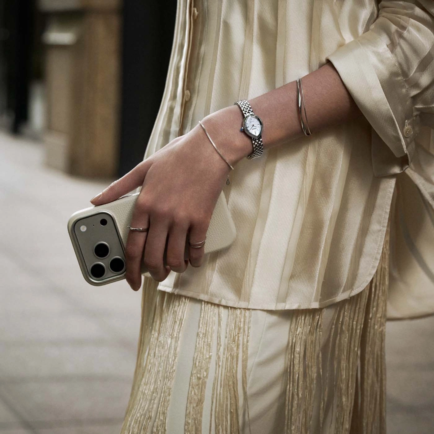Nahaufnahme von einem Frauenarm mit Uhr und Handy.
