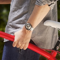 Person im grauen Hemd hält roten Fahrradrahmen, trägt eine Uhr.