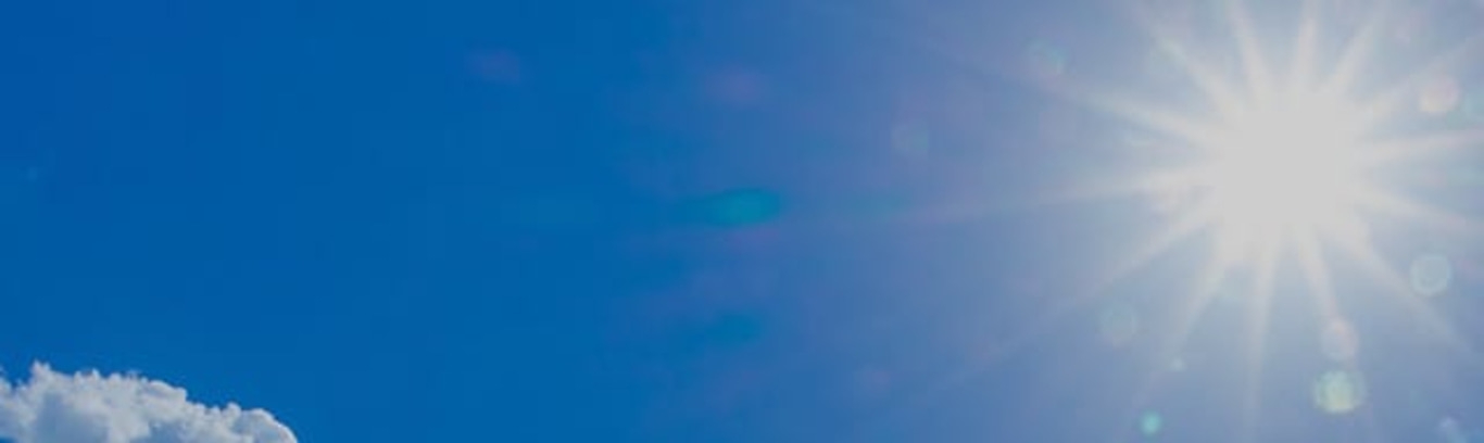 Helle Sonne am klaren blauen Himmel mit ein paar Wolken.