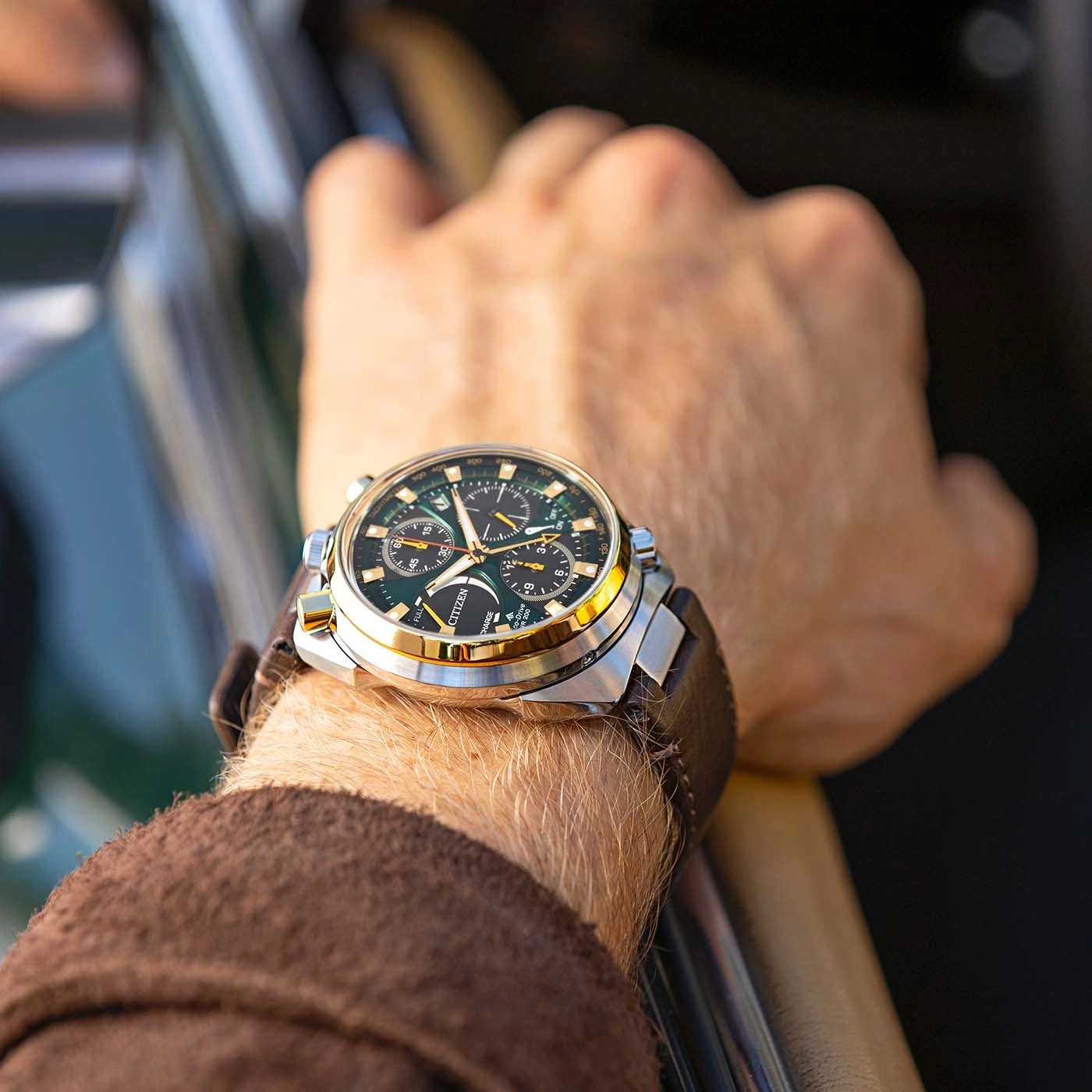 Ein Mann trägt eine Citizen-Uhr am Handgelenk und fährt ein Auto.