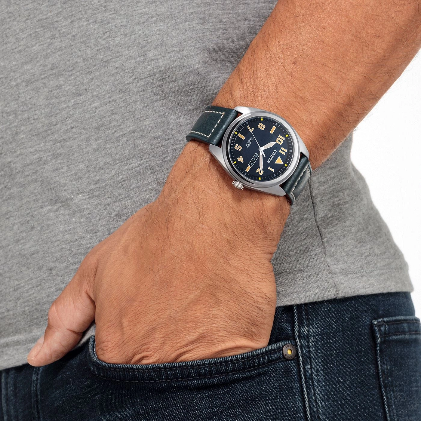 Mann mit Citizen-Uhr, blaues Armband, in der Hosentasche.