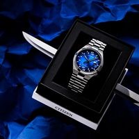 Eine blaue Citizen Automatik-Uhr in einer schwarzen Schachtel auf blauem Knitterpapier.