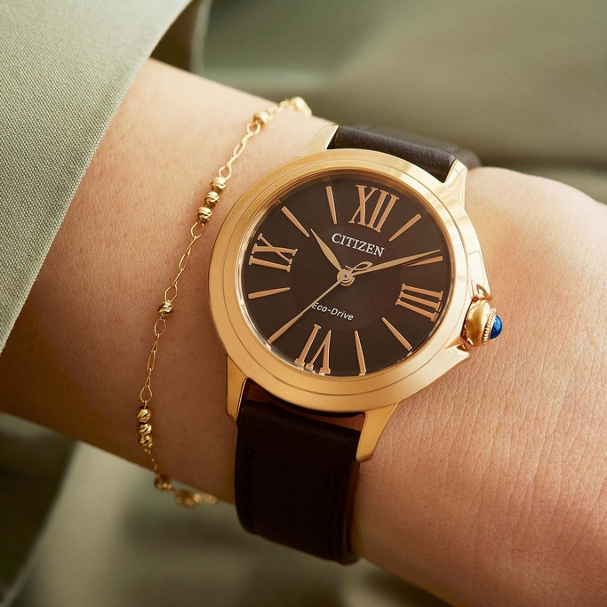 Nahaufnahme einer Citizen-Uhr am Handgelenk mit goldenem Armband.