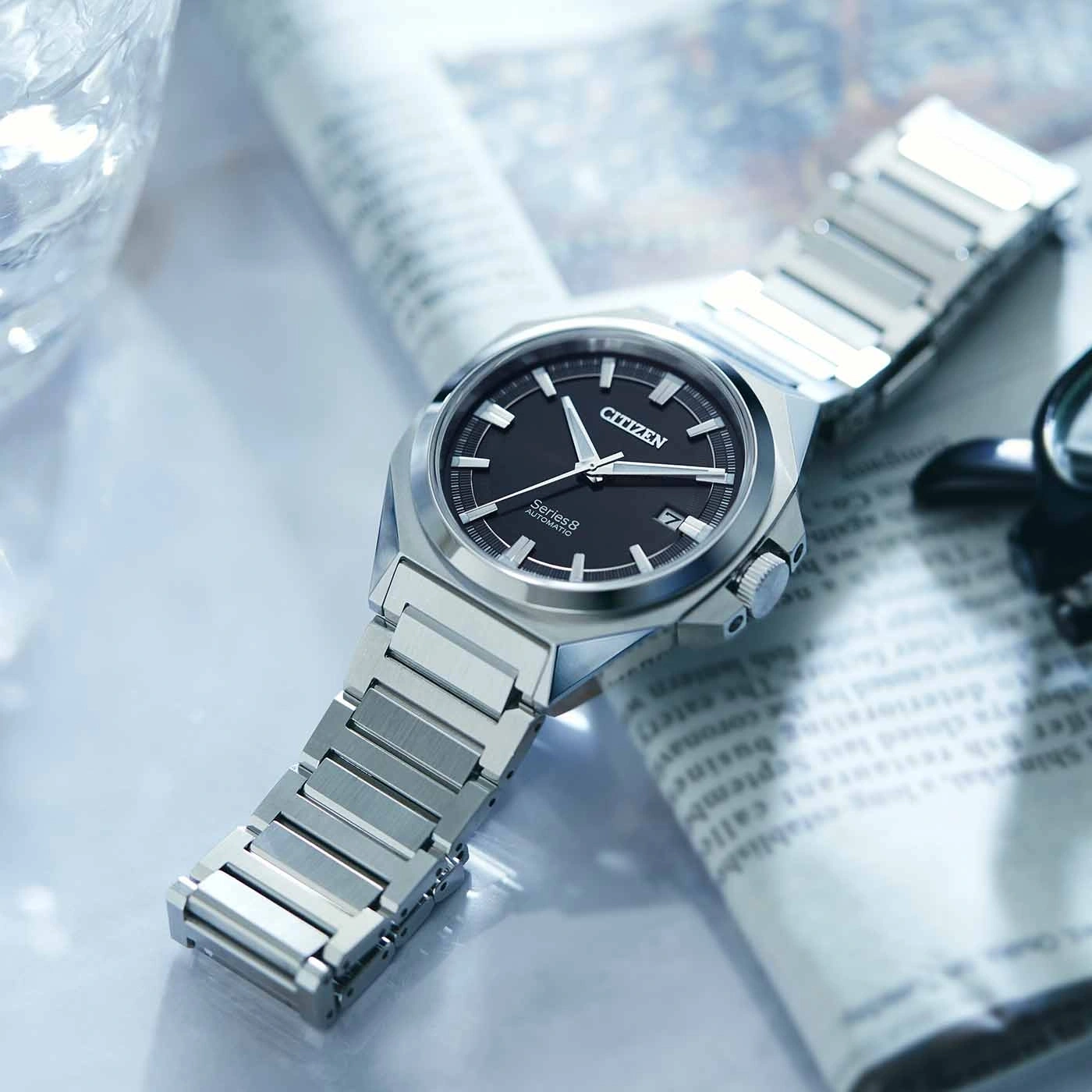 Citizen Series 8 Uhr auf Zeitung, schwarzes Zifferblatt, silbernes Armband, Nahaufnahme