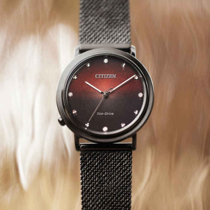 Citizen-Uhr mit schwarzem Armband und rotem und schwarzem Zifferblatt.