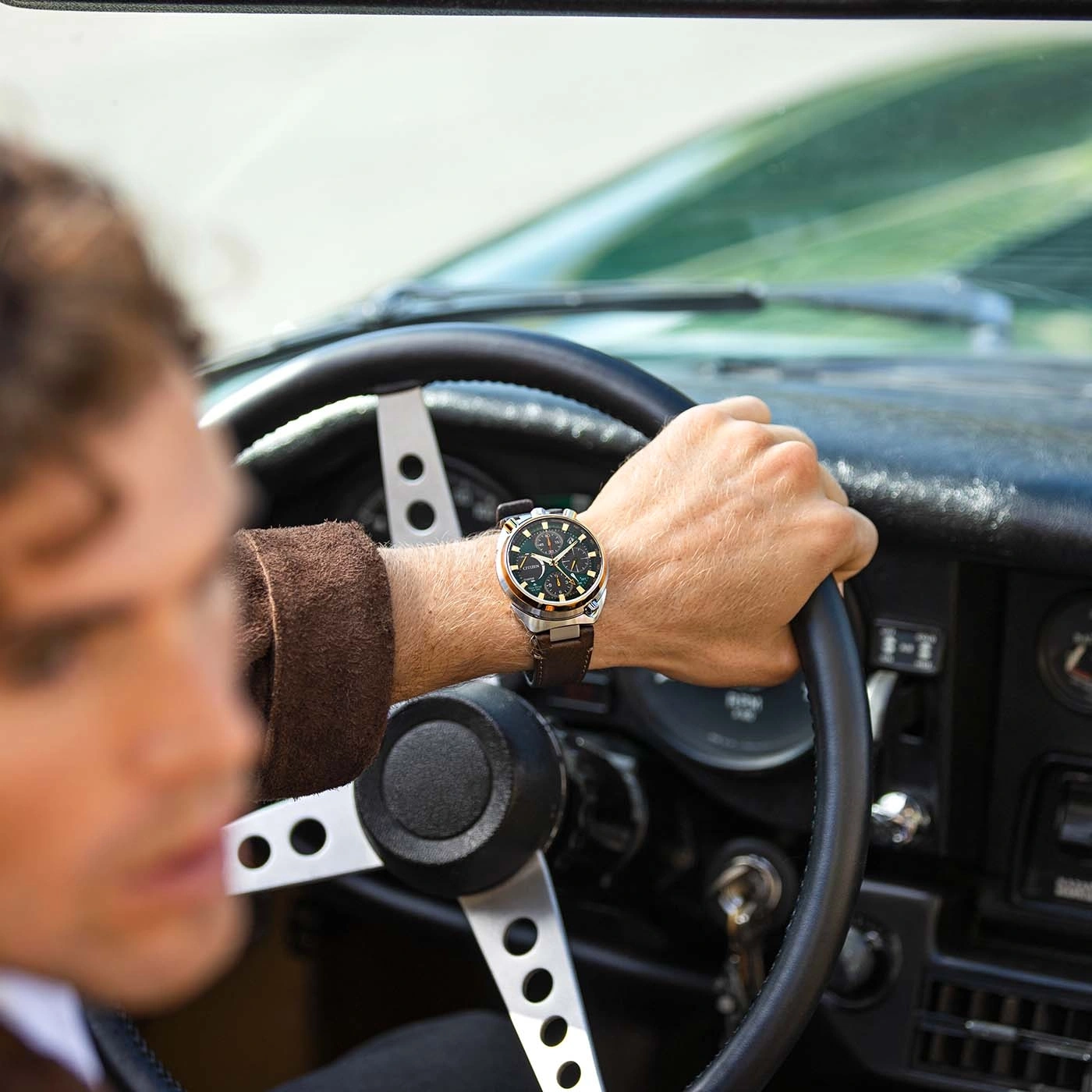 Mann fährt Oldtimer, trägt Uhr