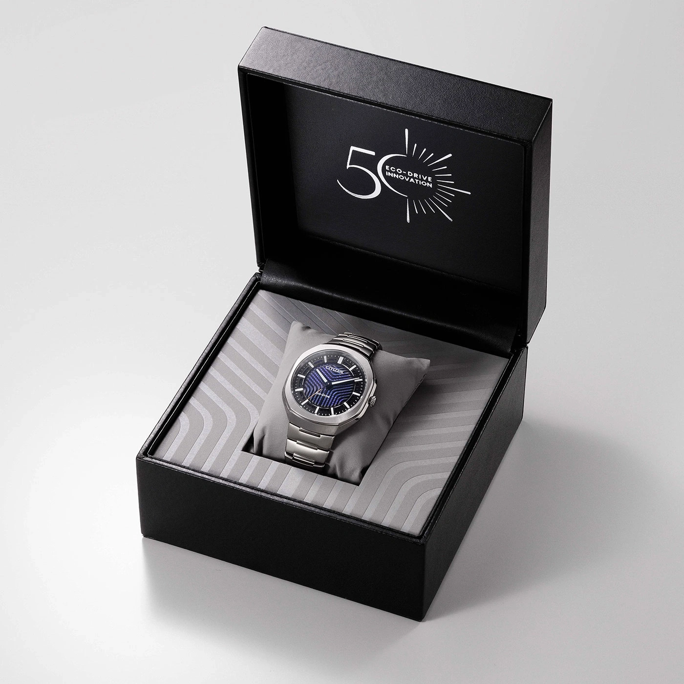 Eine silberne Uhr in einer schwarzen Schachtel mit "50 Eco-Drive Innovation" auf dem Deckel.