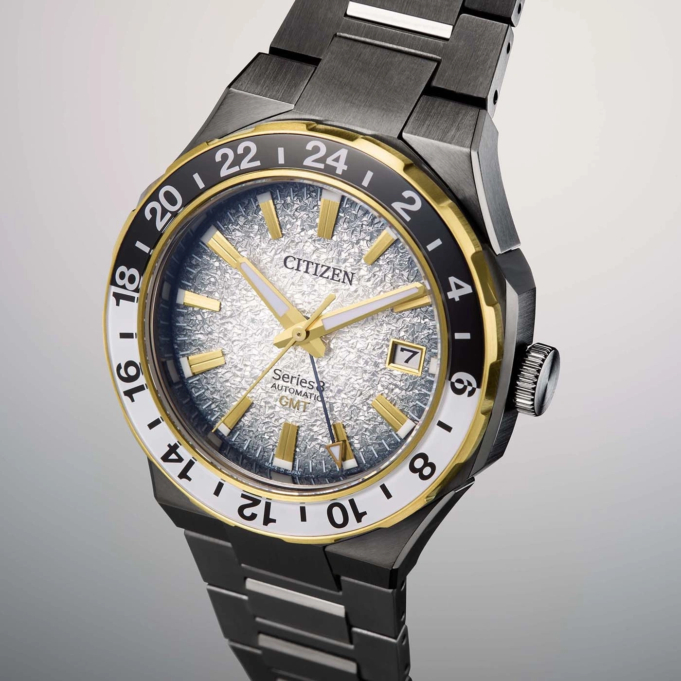 Citizen-Uhr mit goldenen Akzenten, schwarzer Lünette und strukturiertem silbernen Zifferblatt.