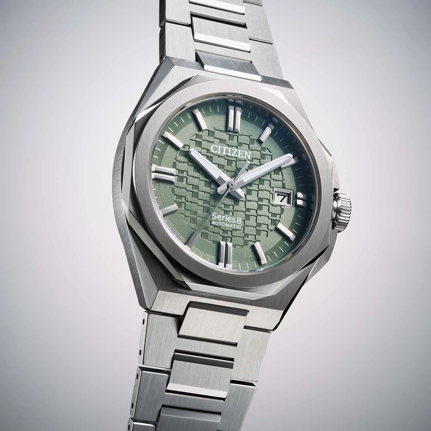 Nahaufnahme einer Citizen Series 8 Automatik-Uhr mit grünem Zifferblatt und Edelstahlarmband im Studio.