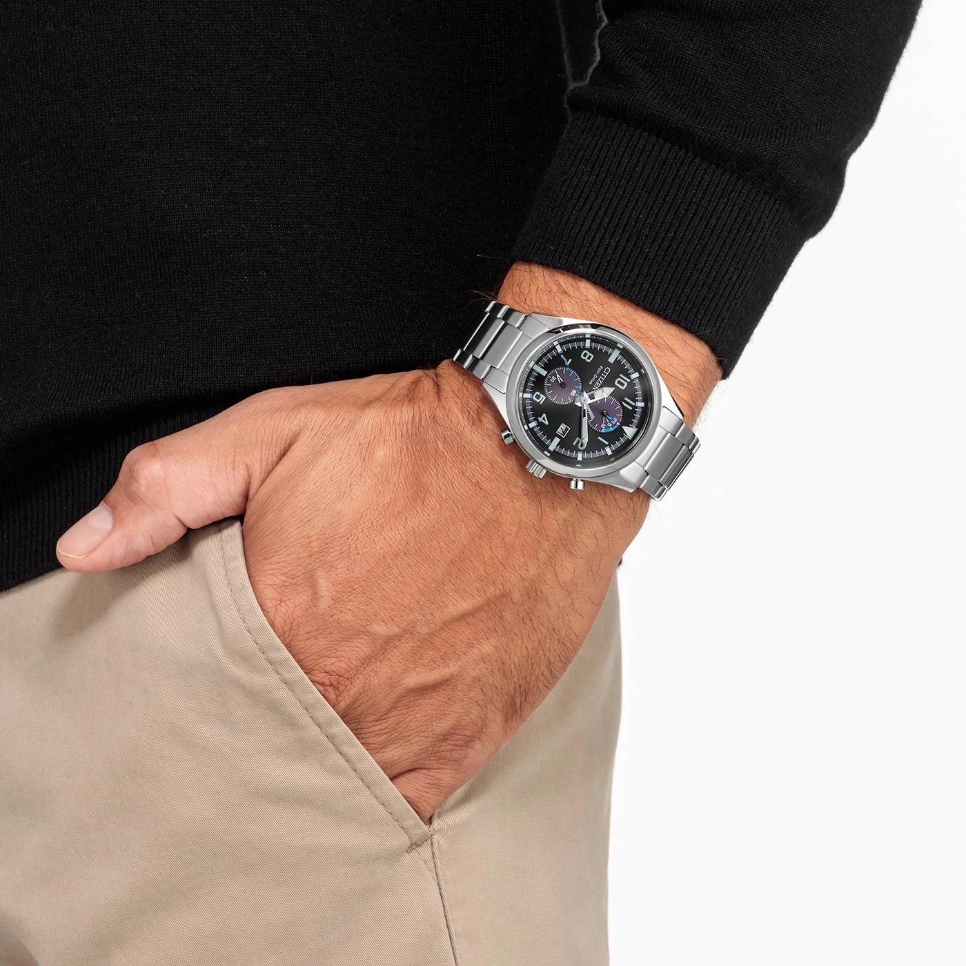Mann mit silberner Uhr, schwarzem Pullover und khakifarbener Hose.
