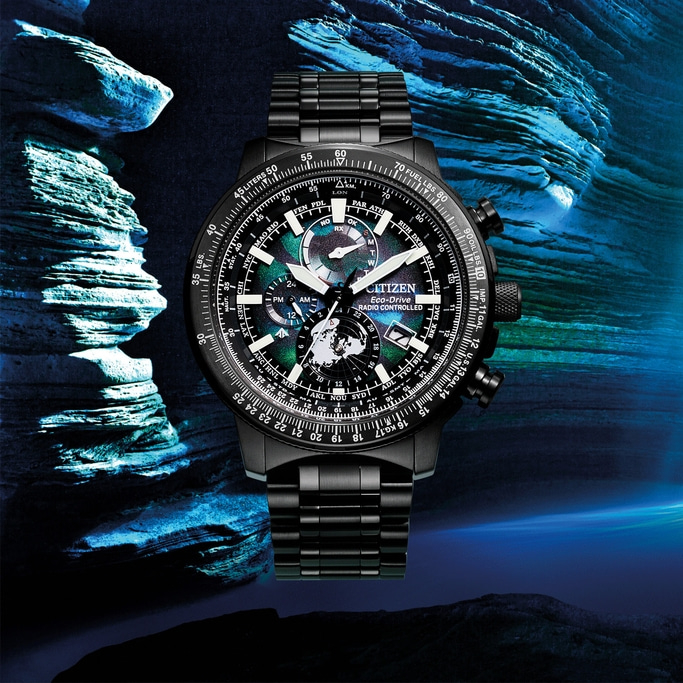 Schwarze Citizen-Uhr mit kompliziertem Zifferblatt und Armband, vor blauem Hintergrund.