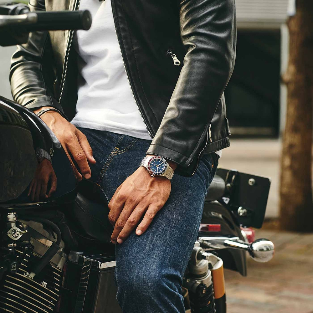 Mann auf Motorrad mit Uhr und Lederjacke, Jeans. Stilvolles Outfit.