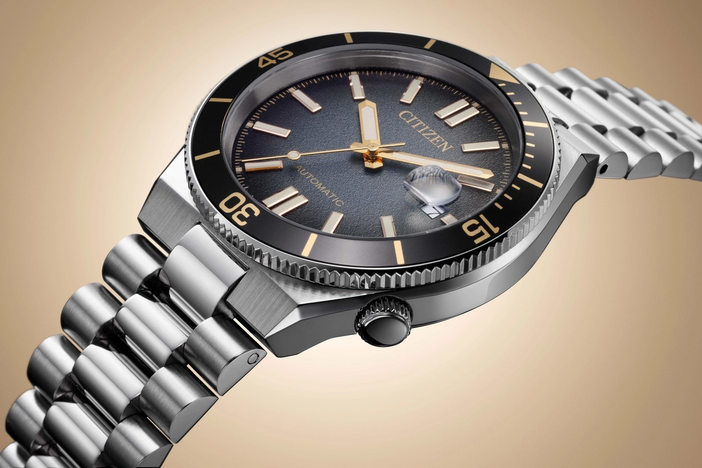 Nahaufnahme einer Citizen Automatik-Taucheruhr mit Metallarmband vor schlichtem Hintergrund.