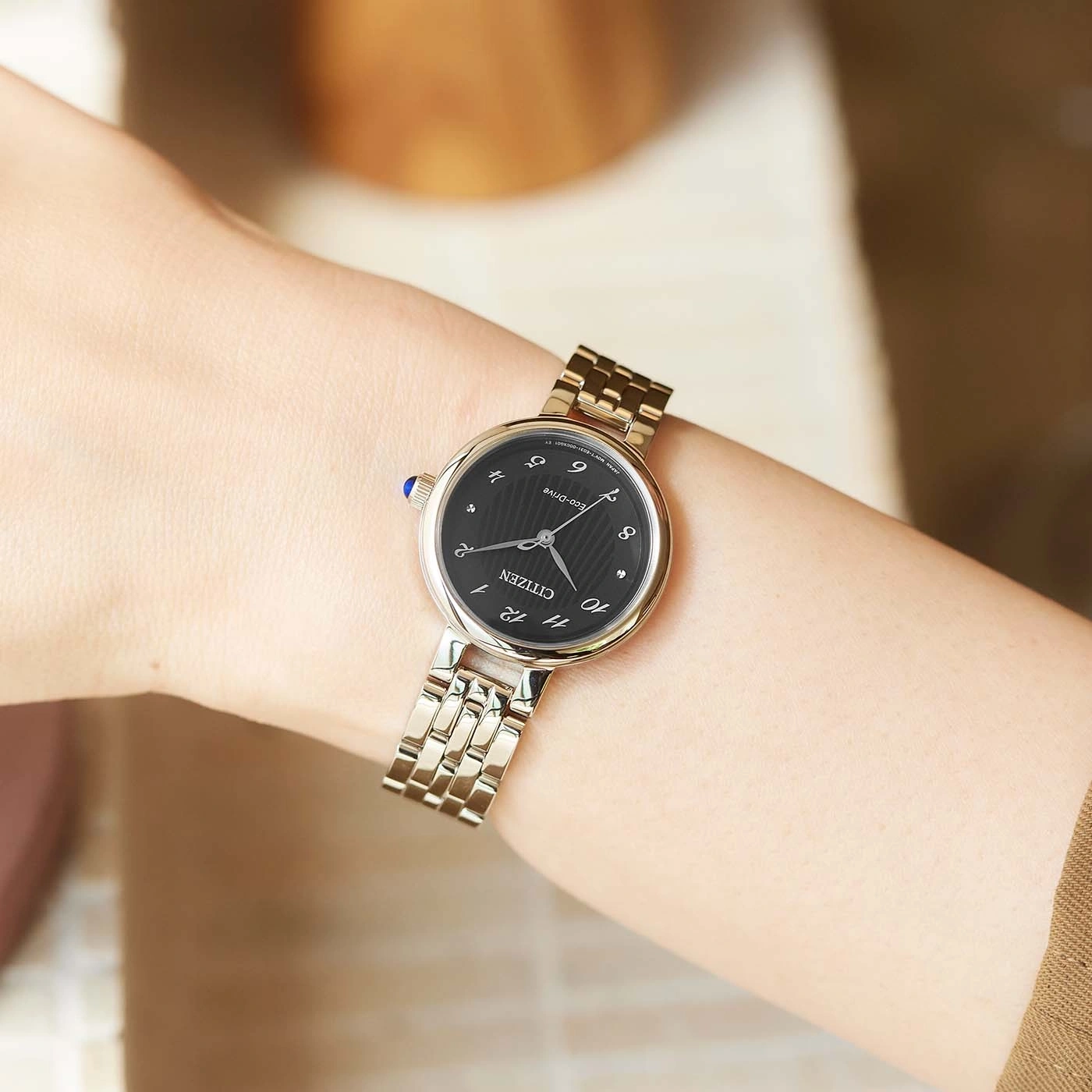Armbanduhr am Handgelenk, schwarzes Zifferblatt, silbernes Band, Citizen Eco-Drive, elegant.