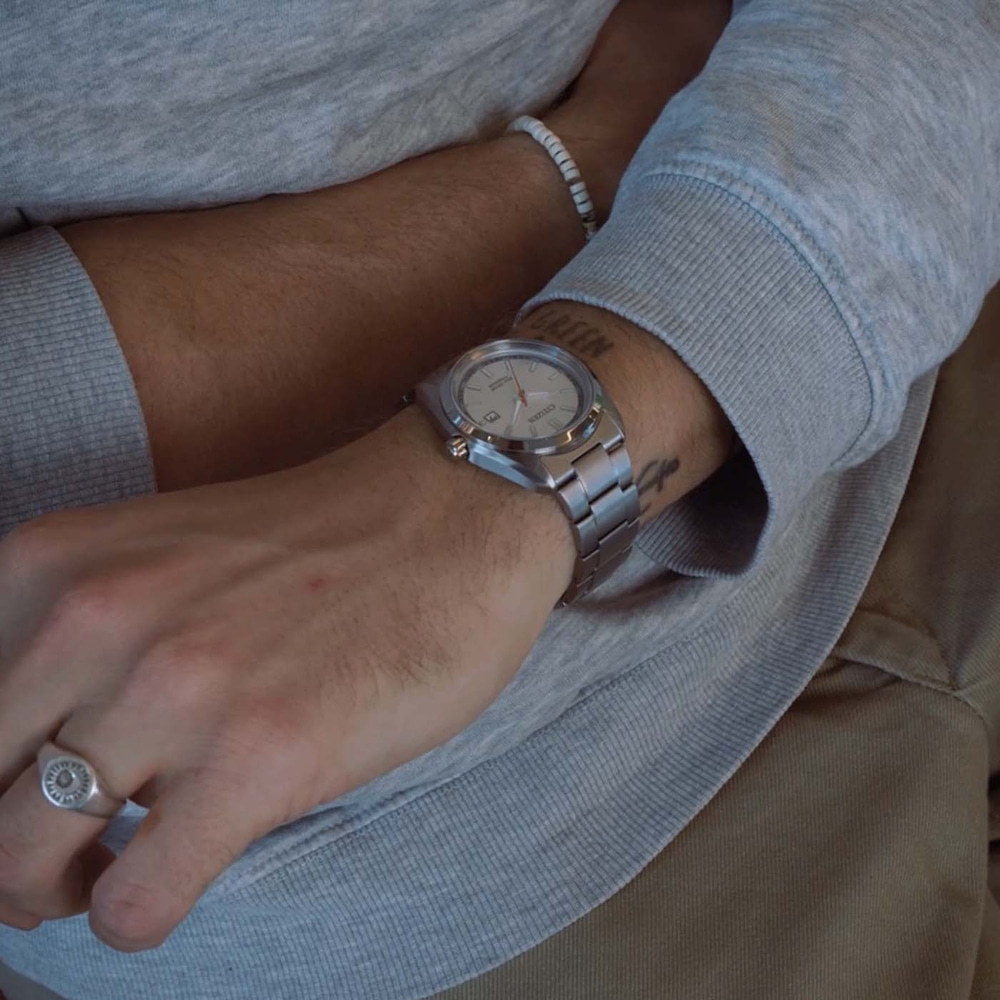 Eine Nahaufnahme des Arms eines Mannes mit Uhr und Ring.