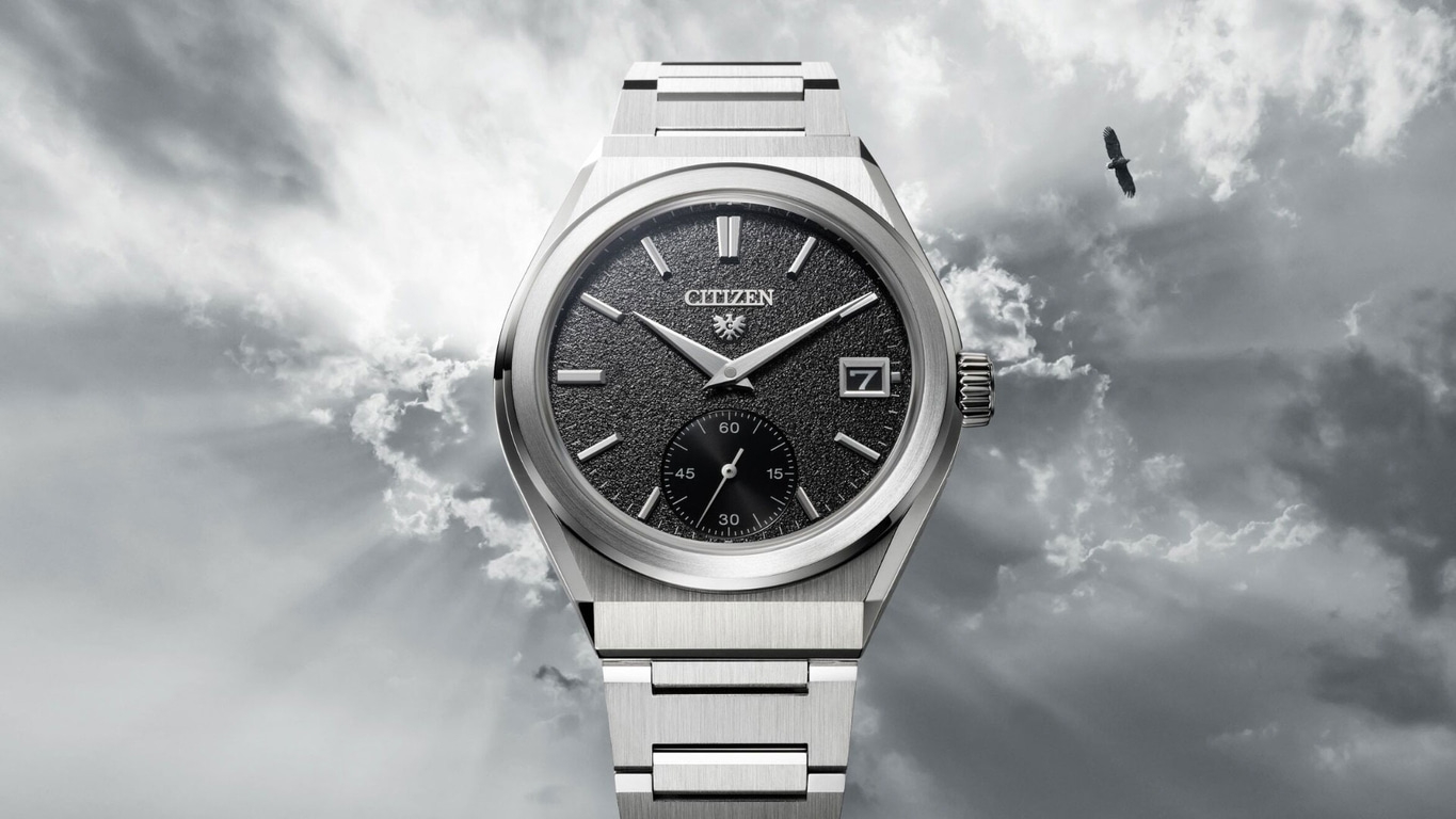 Citizen-Uhr mit schwarzem Zifferblatt, silbernem Armband und Adler am Himmel.