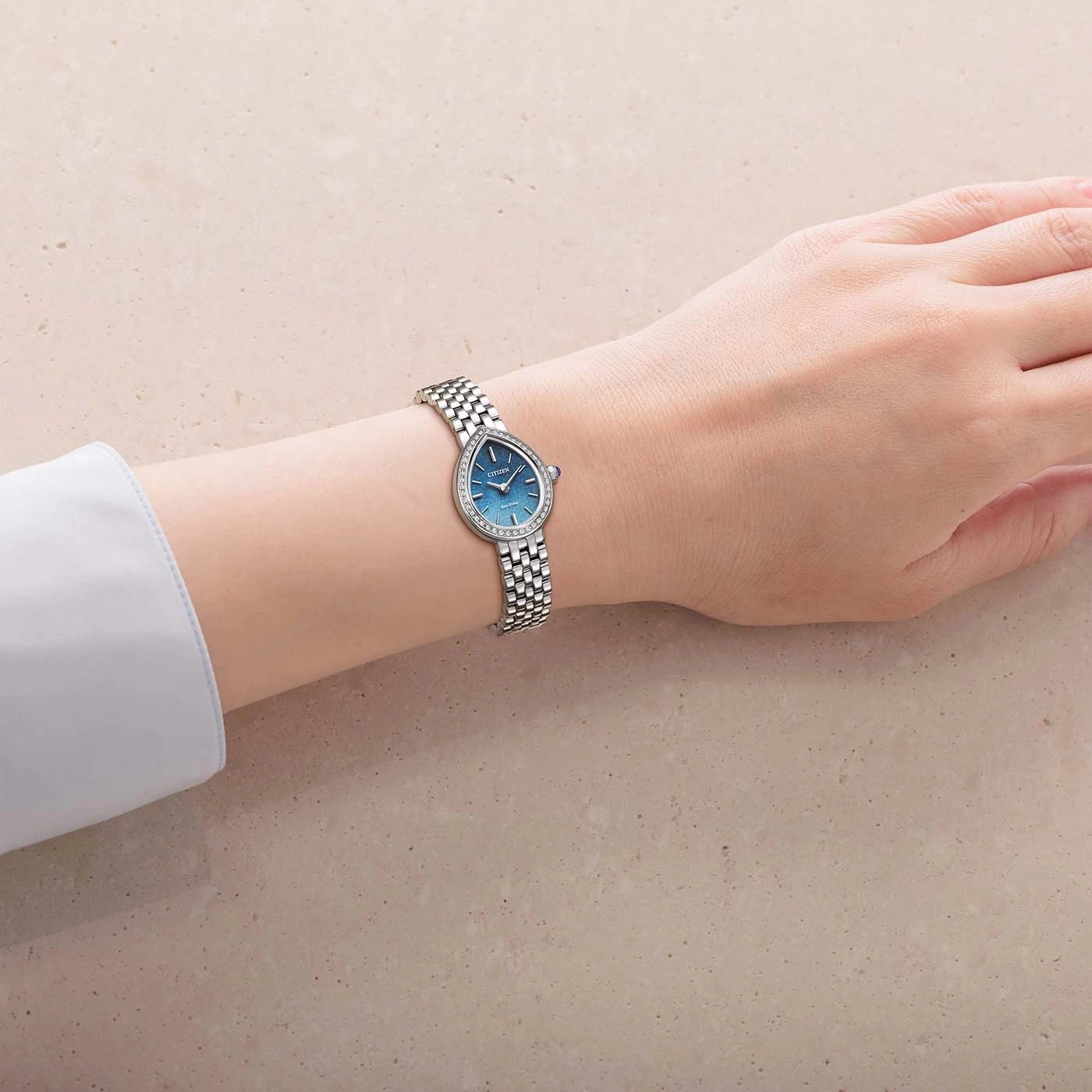 Damenarm mit einer Tränenschmuckuhr mit Diamanten.