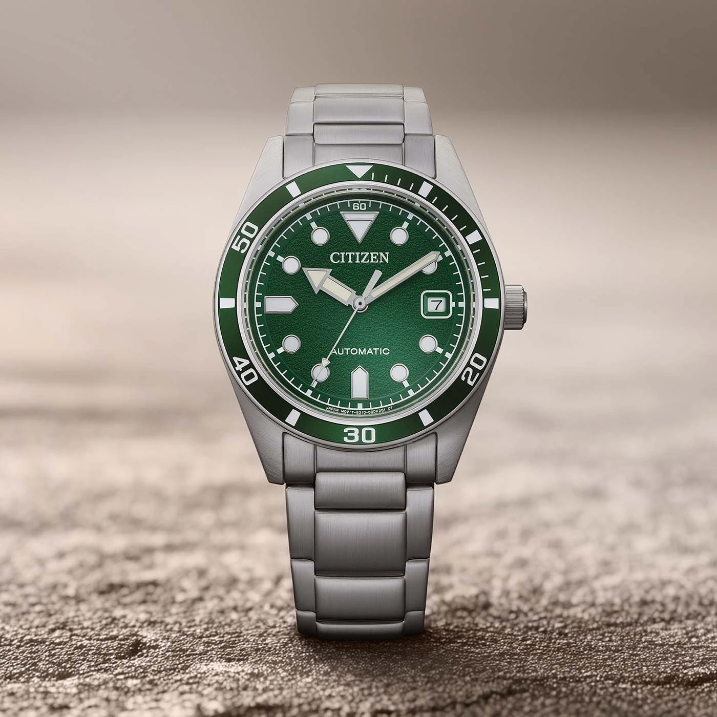 Eine grüne Citizen Automatik-Uhr mit Metallarmband.