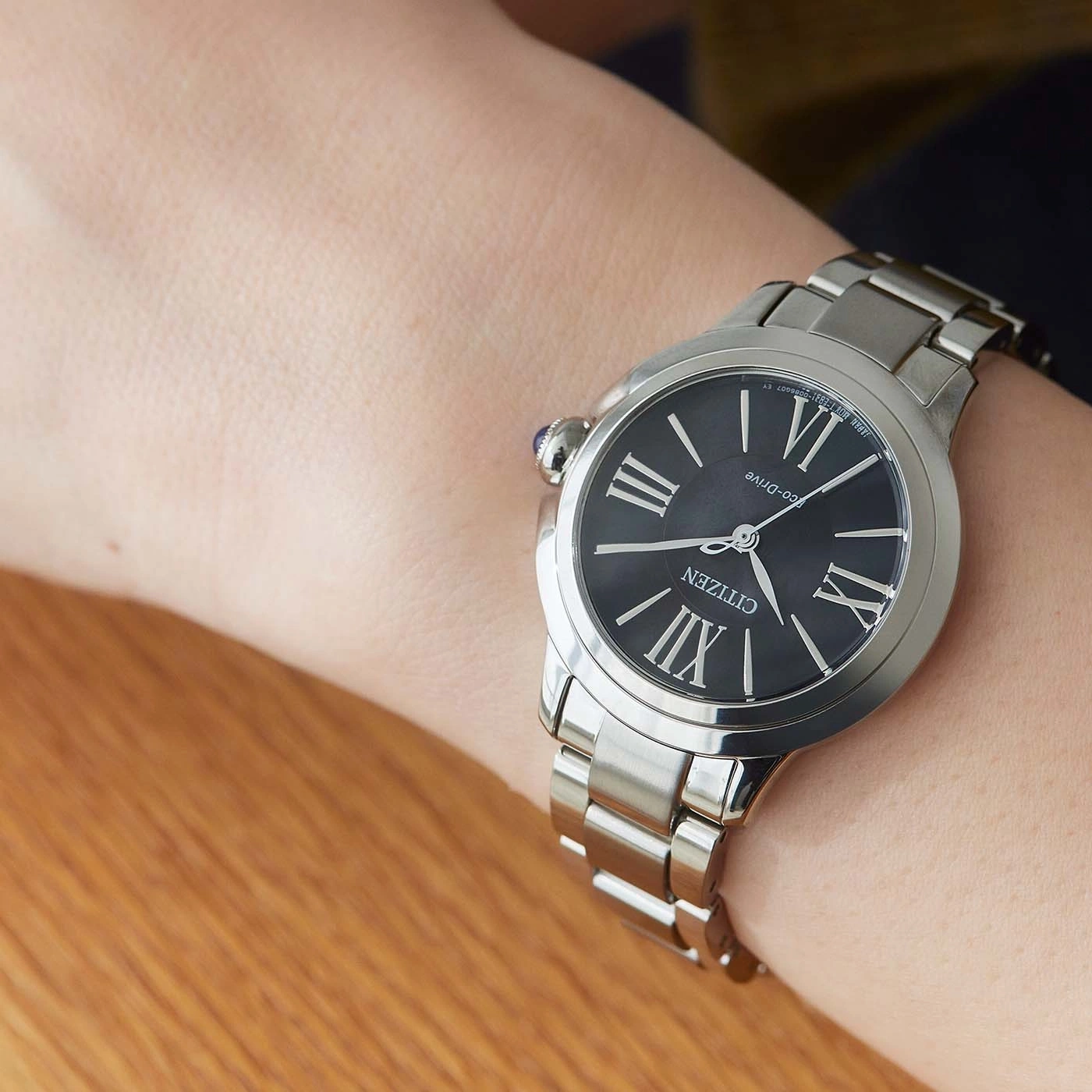 Citizen-Uhr am Handgelenk, schwarzes Zifferblatt, silbernes Armband, römische Ziffern, Eco-Drive, Nahaufnahme