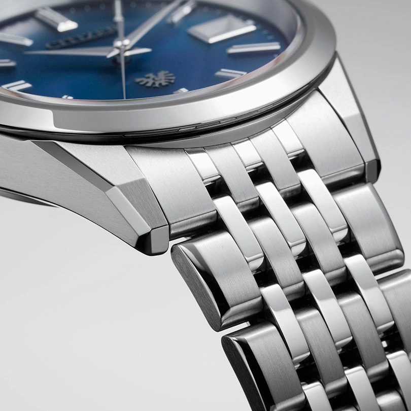 Nahaufnahme einer silbernen Uhr mit blauem Zifferblatt und Metallarmband.