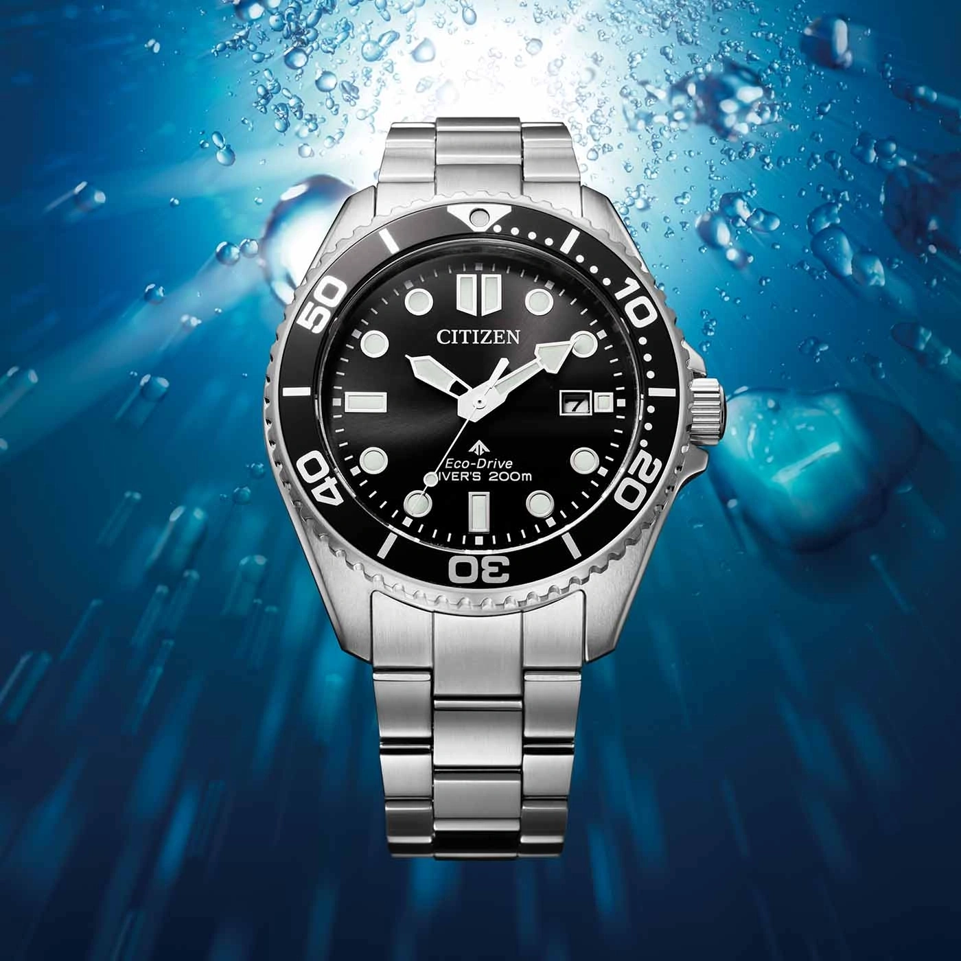 Citizen-Uhr mit schwarzem Zifferblatt und silbernem Armband, Unterwasserhintergrund.