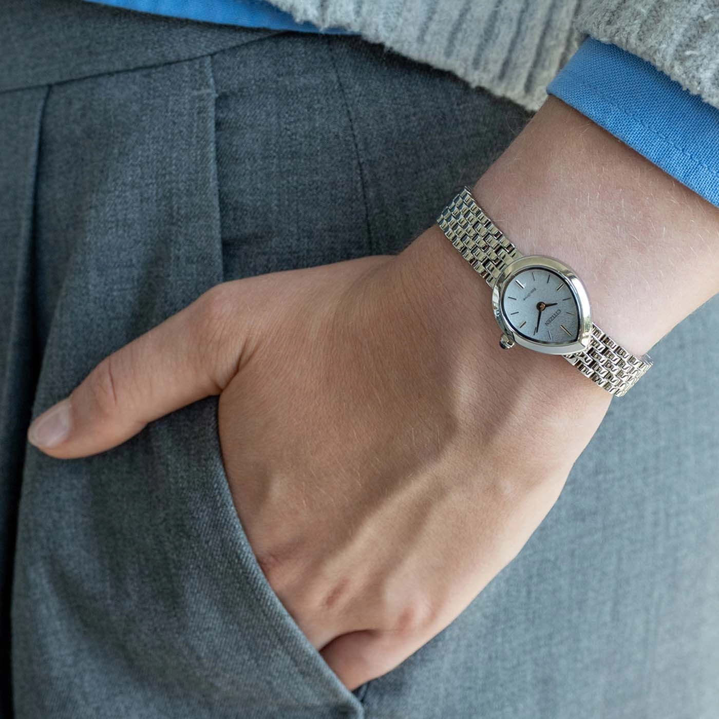 Person trägt eine silberne Uhr am linken Handgelenk, Hand in der Tasche.