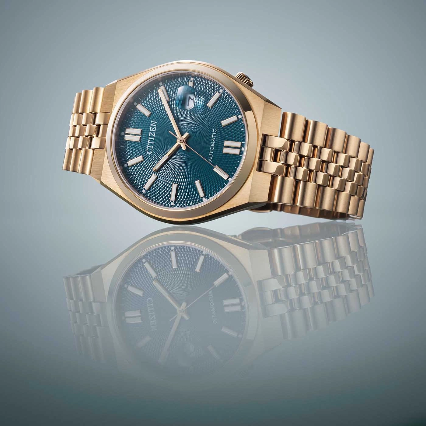 Goldene Citizen-Uhr mit blauem Zifferblatt und Spiegelung auf Oberfläche.