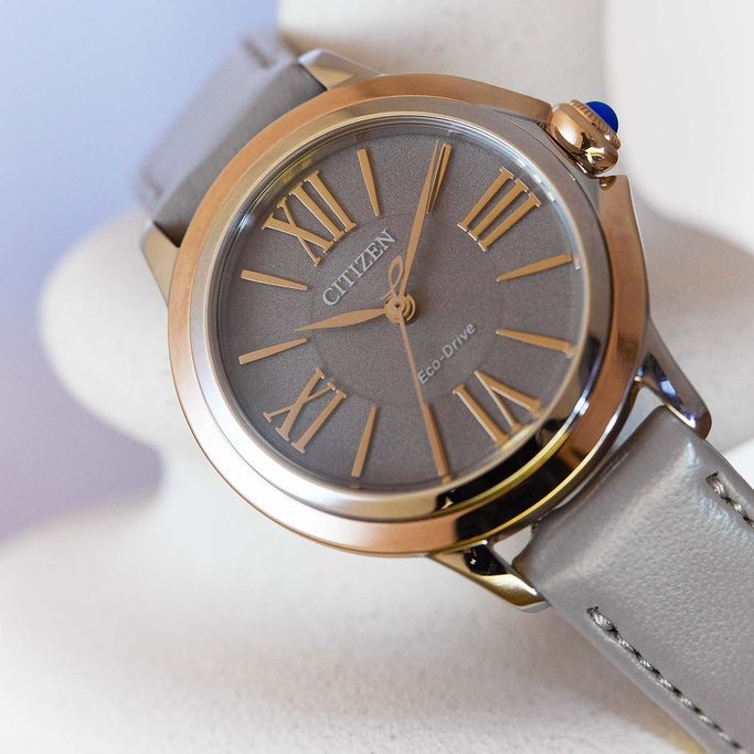 Citizen Eco-Drive Uhr mit grauem Zifferblatt und Lederarmband, goldfarbene Akzente.