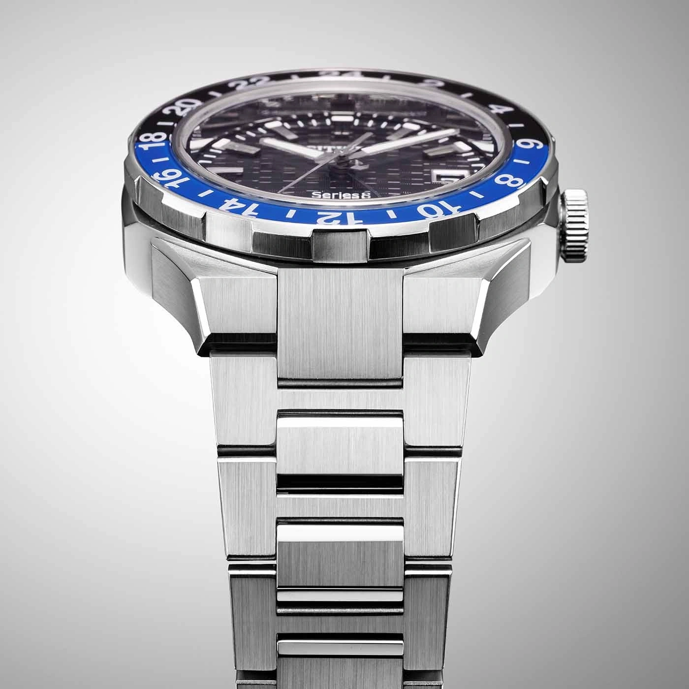 Nahaufnahme einer silbernen Uhr mit blau-schwarzer Lünette und Metallarmband.