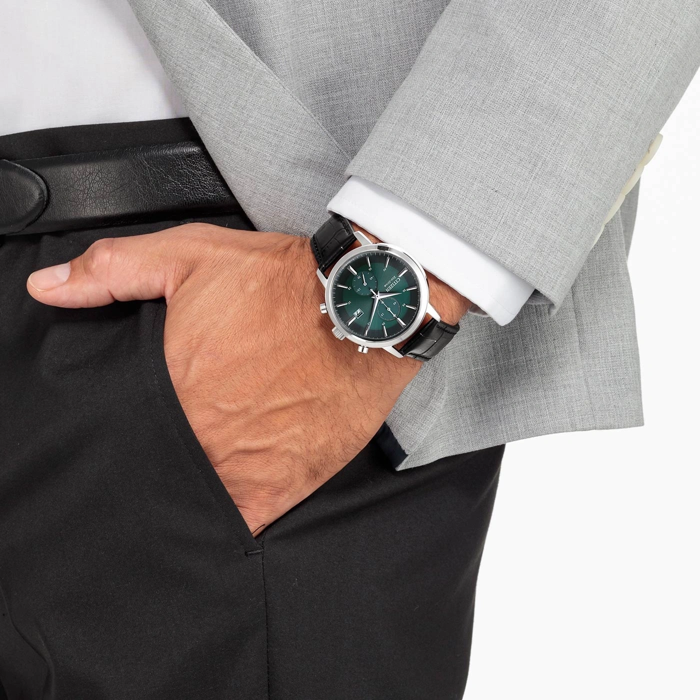 Mann mit Uhr, Anzug und schwarzer Hose, Hand in der Tasche.