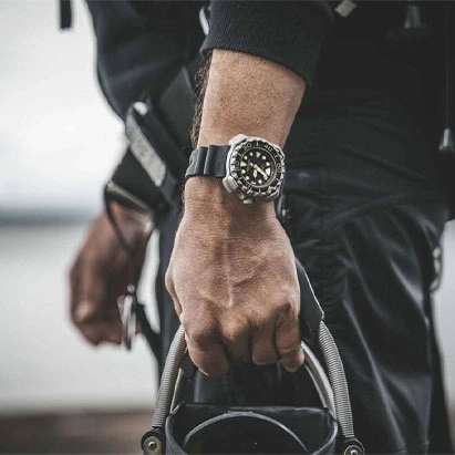 Mann mit Uhr, hält Ausrüstung, Nahaufnahme, schwarzes Outfit, Outdoor-Aktivität