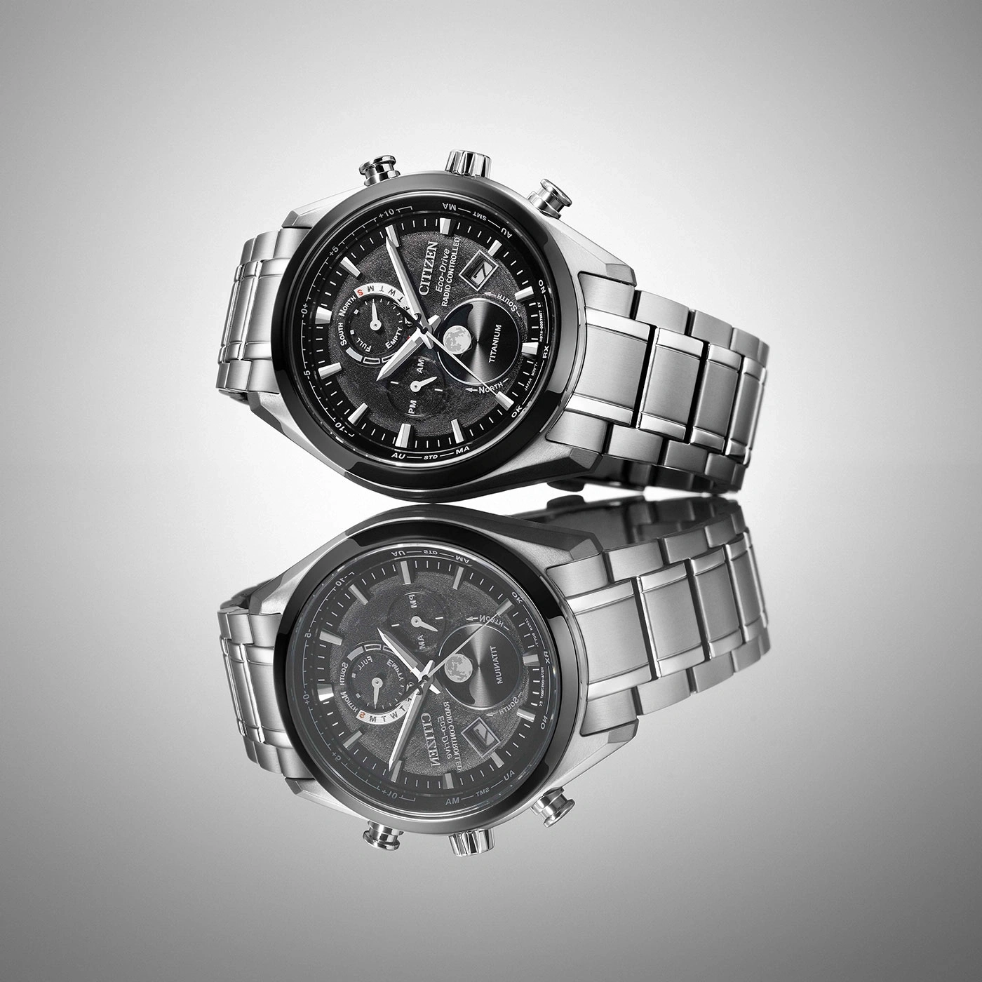 Citizen-Uhr mit schwarzem Zifferblatt und silbernem Armband, reflektiert auf einer Oberfläche.