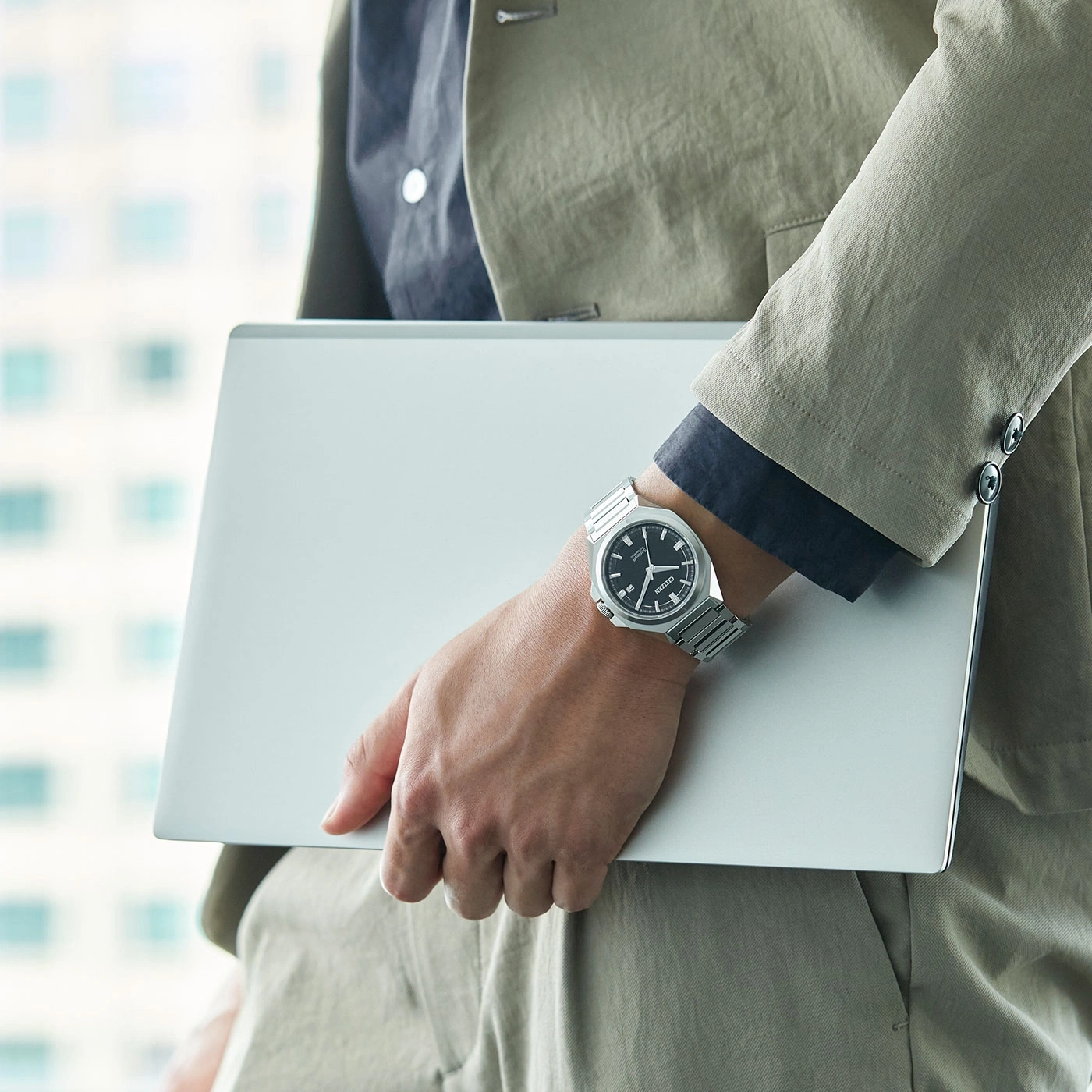 Mann hält Laptop, trägt Uhr und Anzug. Geschäftsmann.