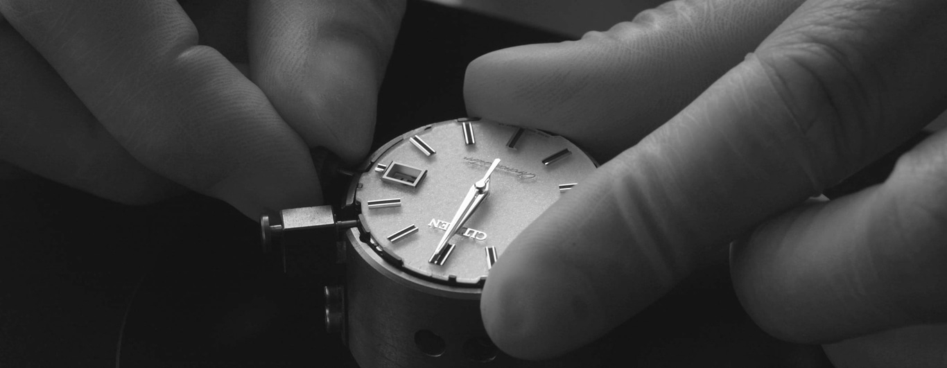 Hände halten eine Uhr. Uhrenreparatur. Nahaufnahme des Zifferblatts.