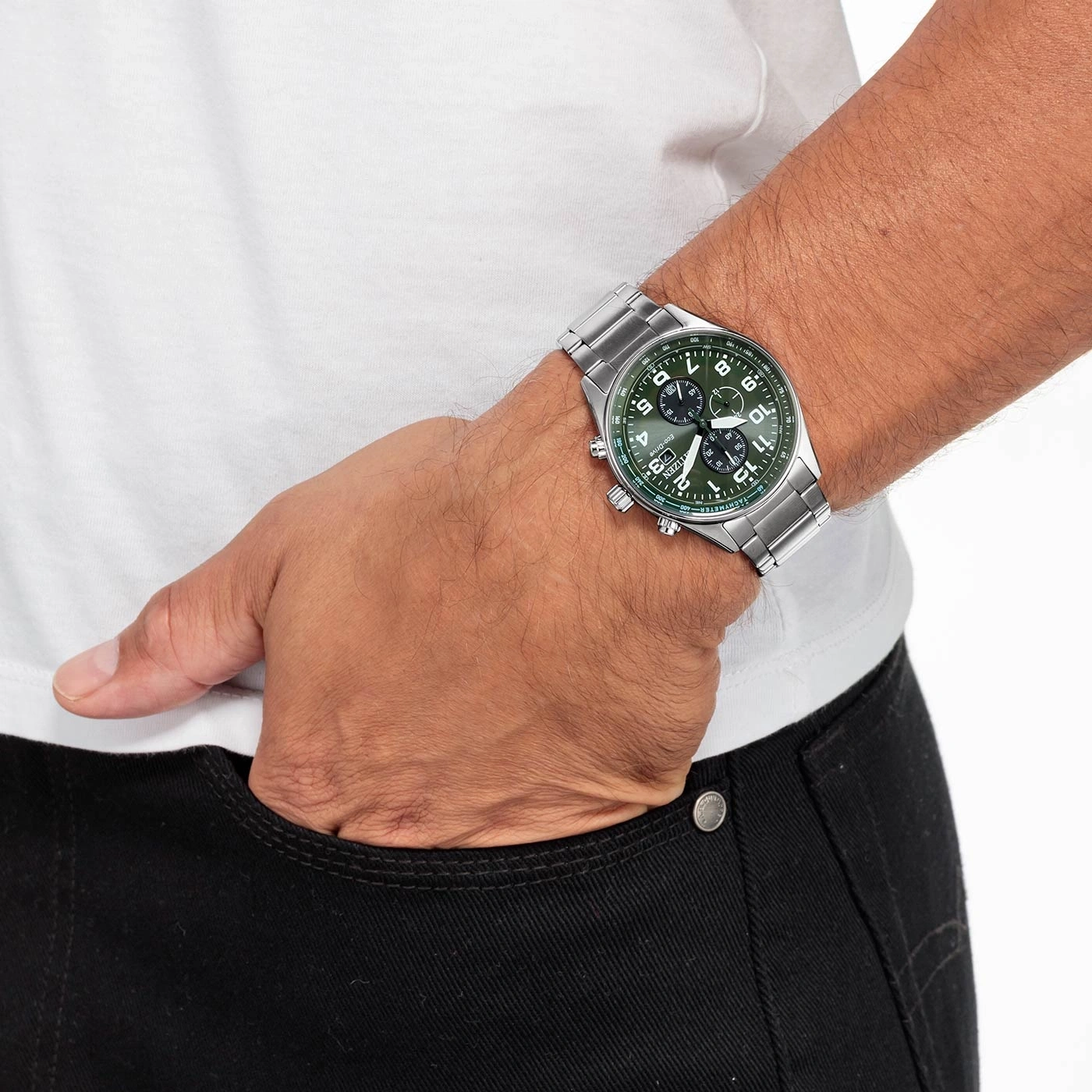 Mann mit silberner Uhr und grünem Zifferblatt, Hand in der Hosentasche.