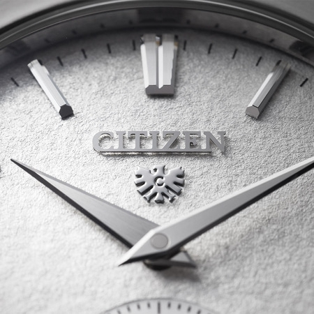 Nahaufnahme eines Citizen-Zifferblatts mit silbernen Zeigern und Markierungen.