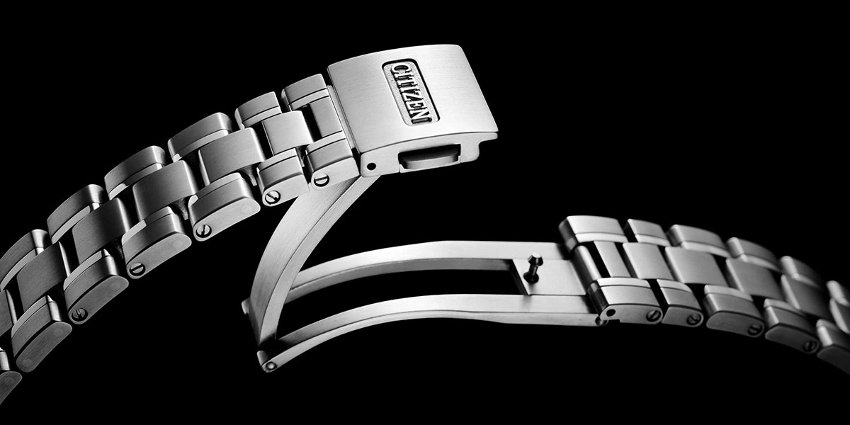 Nahaufnahme eines Citizen-Uhrenarmbandverschlusses, Edelstahl, schwarzer Hintergrund.