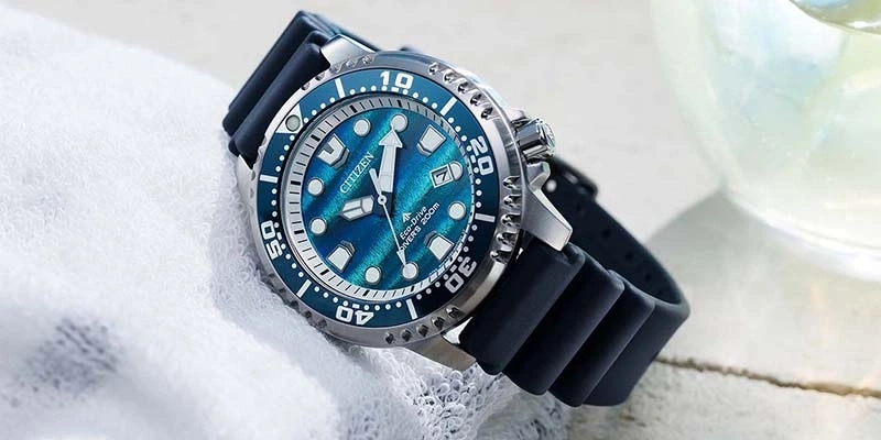Eine blaue Citizen Eco-Drive Taucheruhr mit Kautschukband ruht auf einem weißen Handtuch.