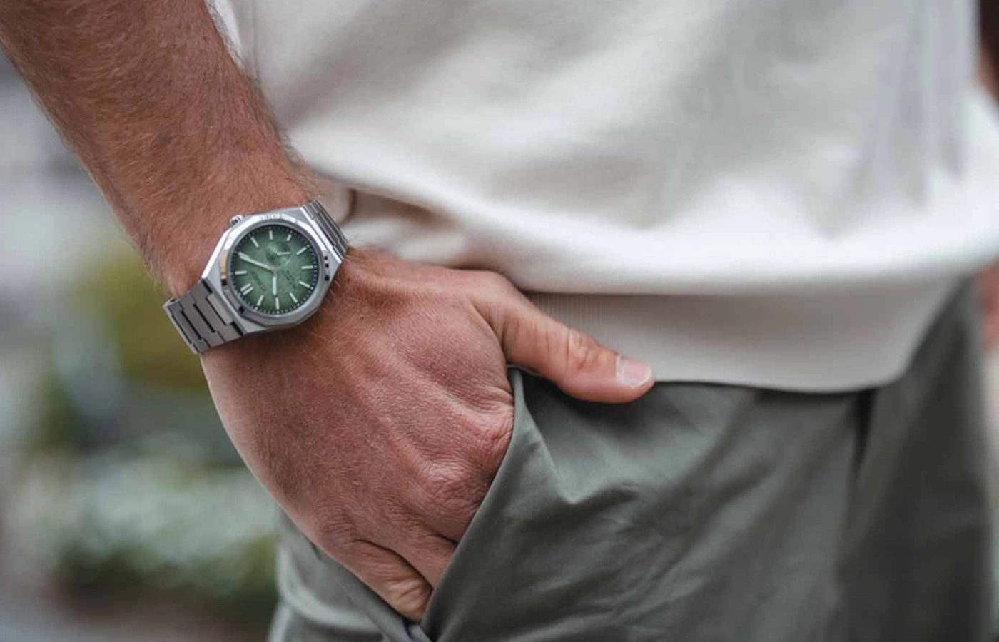 Mann mit Uhr mit grünem Zifferblatt, Hand in der Tasche, lässiger Stil.