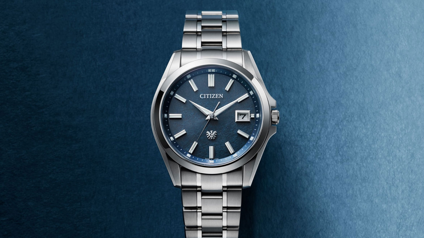 Citizen-Uhr mit blauem Zifferblatt und silbernem Armband auf blauem Hintergrund