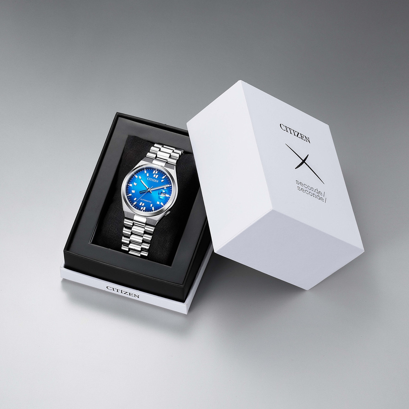 Eine blaue Citizen-Uhr in ihrer Schachtel neben der Verpackung.