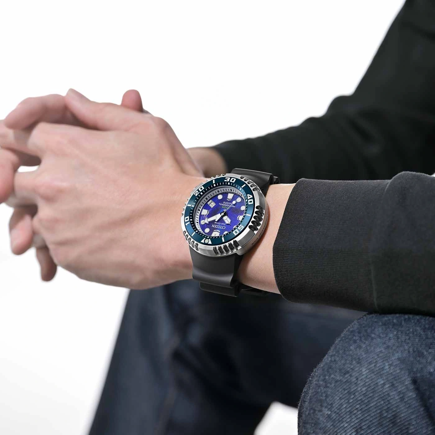 Mann trägt Citizen-Uhr mit blauem Zifferblatt und schwarzem Armband.