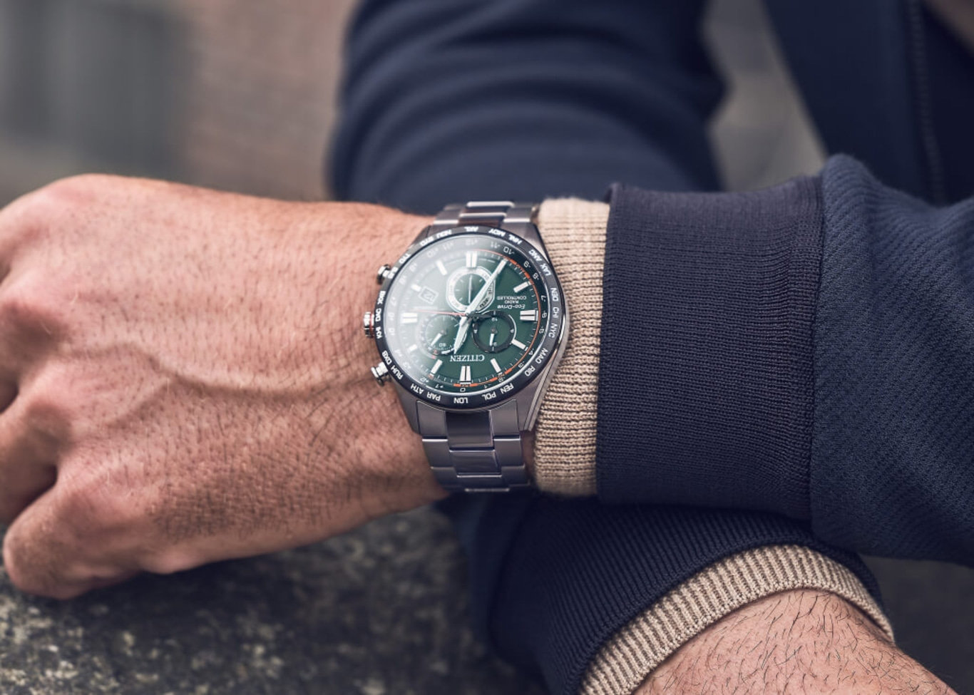 Mann mit Citizen-Uhr mit grünem Zifferblatt und silbernem Armband.