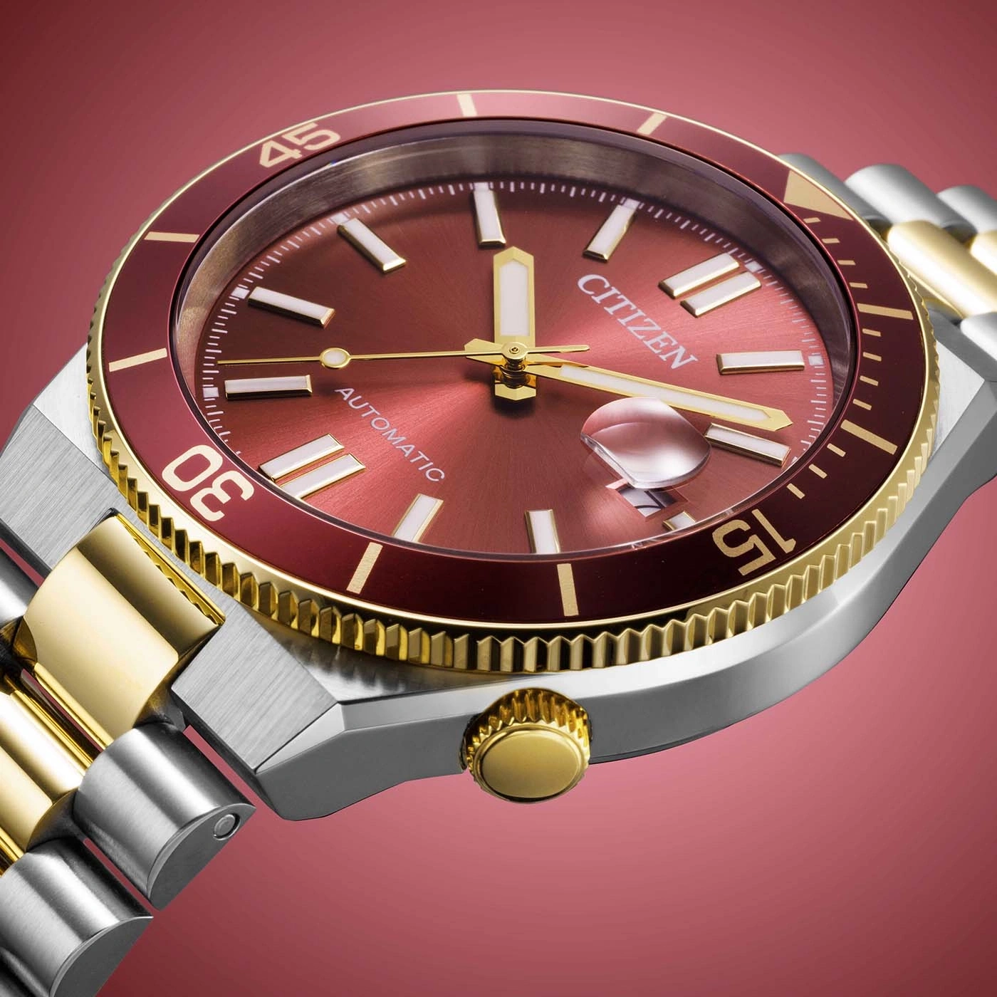 Nahaufnahme einer Citizen Automatik-Uhr mit rotem Zifferblatt und goldenen Akzenten.